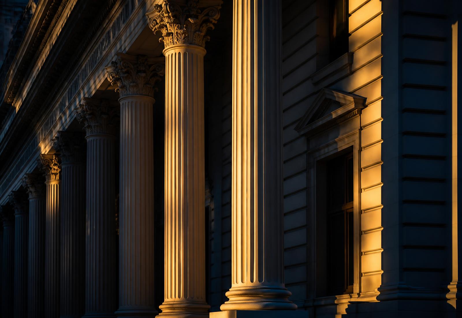Classical colonnade of a European financial institution at golden hour